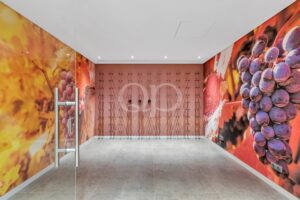 Hallway with vivid grape murals on both sides and a rose wall featuring many coat hooks in the center wall