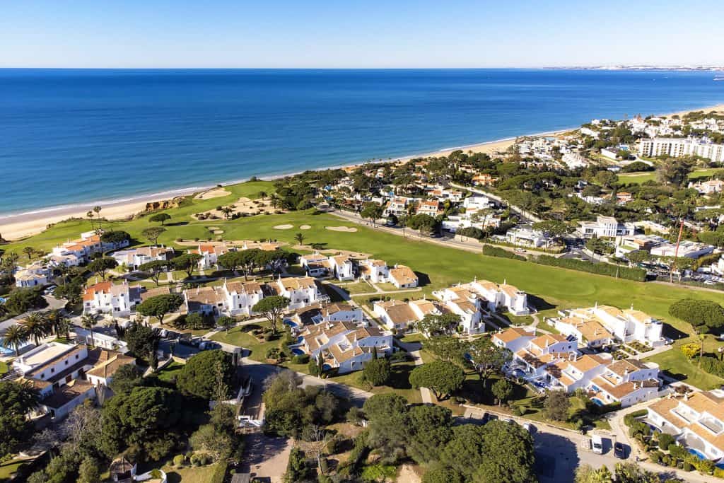 Aerial view of luxury villas and golf course by the beach with ocean views in Algarve, Portugal