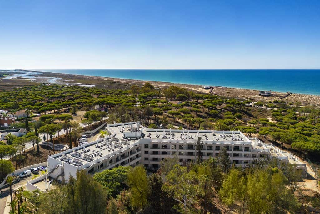 Aerial view of a luxury coastal property surrounded by pine trees with ocean views in Algarve, Portugal