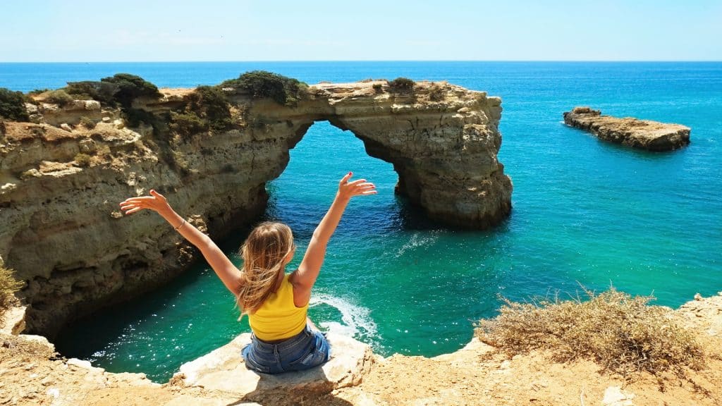 Woman enjoying ocean view from Algarve cliffs