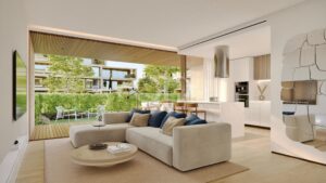 Open-plan living room with a beige sectional sofa and large glass doors opening to a sunny outdoor patio.