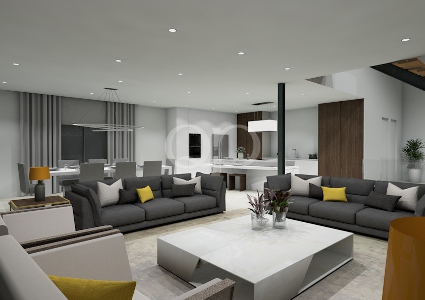 Salon à aire ouverte avec deux canapés modulaires gris disposés autour d'une table basse carrée blanche, des coussins jaunes et un coin repas à l'arrière-plan.