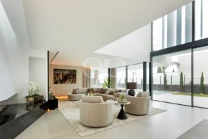 Open plan sitting room with double height ceiling and garden access