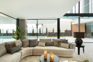 Spacious sitting room with curved sofa and floor to ceiling glazing