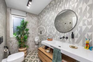 Badezimmer mit begehbarer Dusche, gemusterten Wänden und Doppelwaschtisch