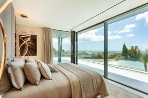 Bedroom with floor to ceiling glazing and panoramic sea views