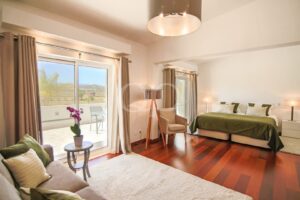 Bedroom with terrace access, wood flooring and countryside views