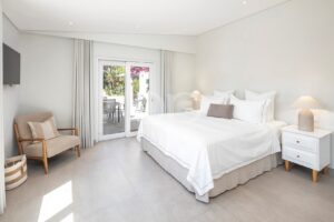 Helles Schlafzimmer mit Zugang zur Terrasse und Blick in den Garten