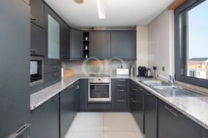 Fully fitted kitchen with dark cabinetry
