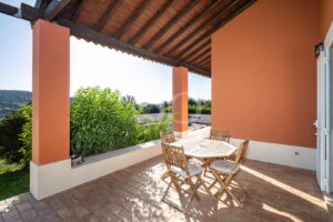 Überdachte Terrasse mit Essbereich im Freien und Blick auf die Landschaft