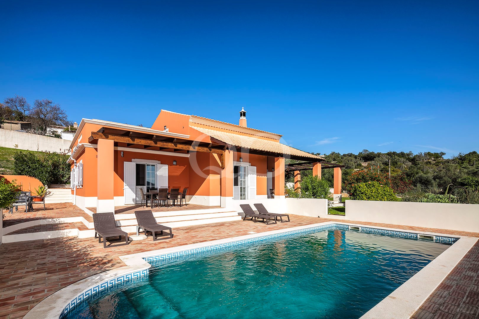 Außenansicht der Villa mit Swimmingpool und überdachter Terrasse