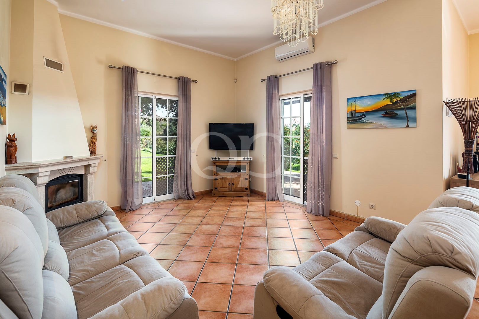 Wohnzimmer mit Kamin und Fenstertüren zur Terrasse
