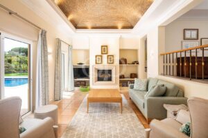 Bright living room with a vaulted brick ceiling, cream walls, and a central fireplace surrounded by built-in shelves and framed art behind.