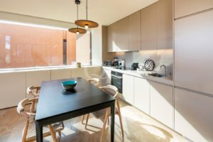 Cozinha compacta contemporânea com zona de refeições, eletrodomésticos integrados e luz natural