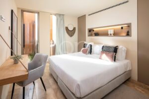 Quarto com cabeceira integrada, arrumação embutida e acesso ao terraço