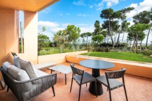 Varanda no rés-do-chão com vista para uma vegetação exuberante e para uma piscina comum