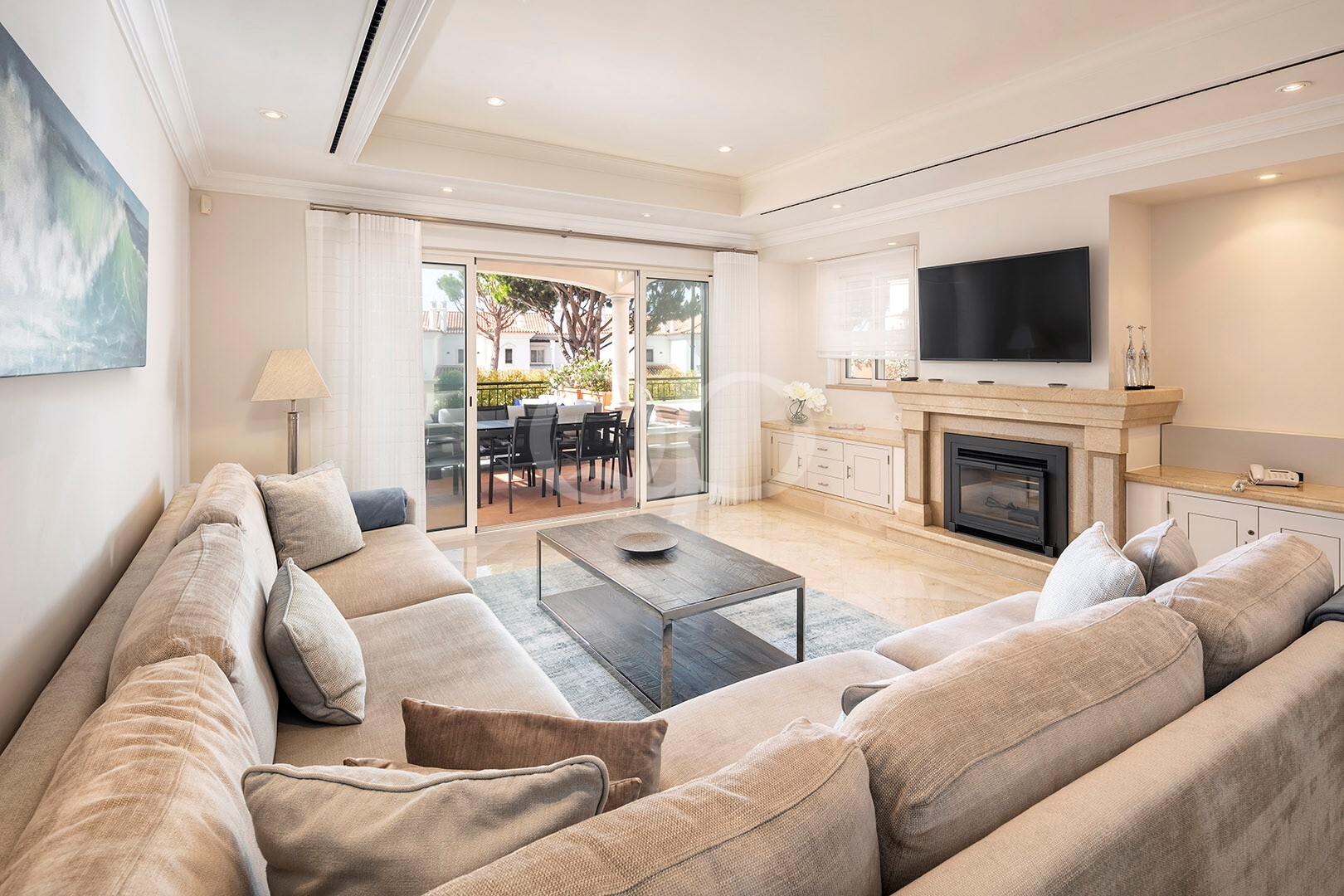 Helles Wohnzimmer mit Kamin und Zugang zur Terrasse