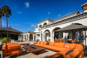 Villa mit Terrasse, die sich durch eine gewölbte Architektur auszeichnet, und Sitzgelegenheiten im Freien