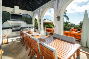 Überdachter Außenbereich zum Essen mit Bogenöffnungen und Blick auf den Pool