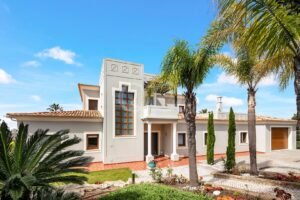 Villa entrance with palm trees and distinctive tower feature