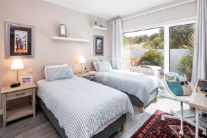 Quarto com acesso ao terraço, poltrona e obra de arte emoldurada