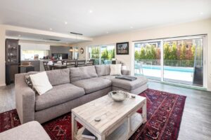 Sala de estar e cozinha em plano aberto, com acesso direto ao terraço da piscina