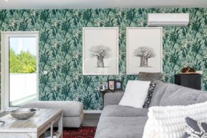 Sala de estar com parede decorativa com motivos botânicos, obras de arte emolduradas e assentos confortáveis