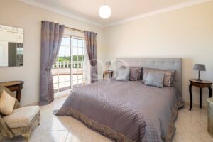 Elegantes, geräumiges Schlafzimmer mit großen Fenstertüren, die auf einen eigenen Balkon führen