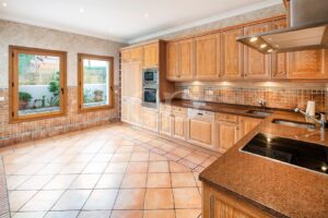 Cuisine équipée traditionnelle avec plans de travail en granit et meubles en bois