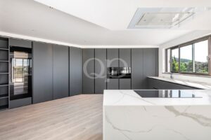Cuisine contemporaine raffinée, dotée d'appareils électroménagers encastrés et d'un îlot central spacieux