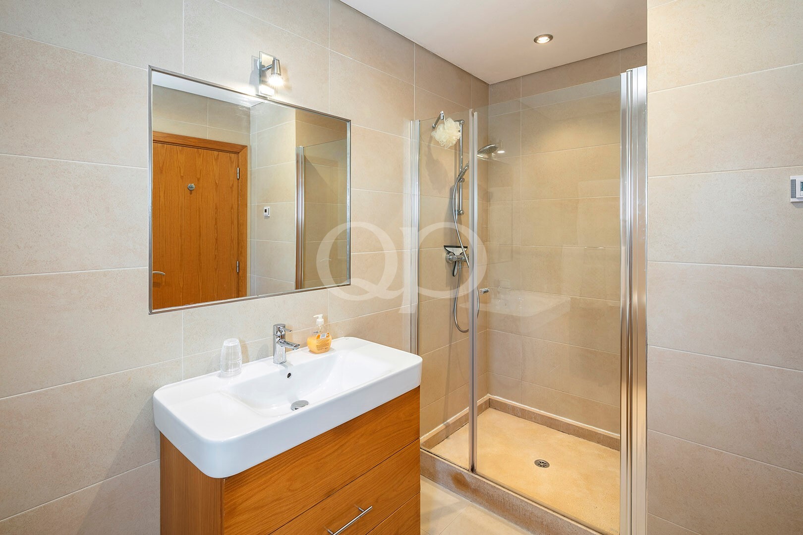 Badezimmer mit Dusche und neutralen Oberflächen