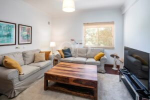 Media room with lounge seating and garden views