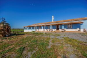 Traditional country house with covered veranda and expansive rural surroundings