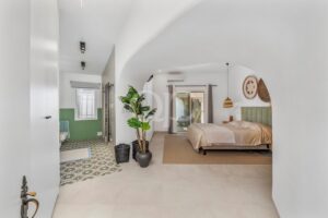 Schlafzimmer mit Gewölbedecke, grünen Akzenten und gemustertem Fliesenboden