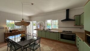 Bright kitchen with mint-green cabinets, glass dining table, and a large woven pendant light. Windowed back wall and stainless appliances visible.