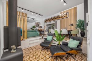 Wohnzimmer mit gemustertem Bodenbelag, Holzvertäfelung und Zugang zum Garten
