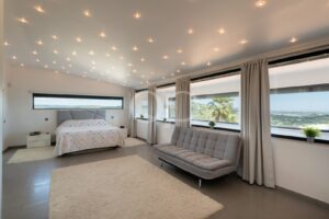 Bedroom with panoramic windows, sitting area and countryside viewsv