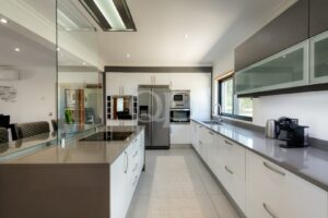 Kitchen with island, integrated appliances and garden views