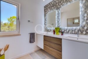Salle de bains avec meuble-lavabo en bois et miroir décoratif