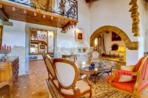 Salle à manger avec un mobilier traditionnel, un plafond en bois et une porte voûtée en pierre