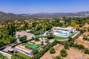 Luftaufnahme einer modernen Villa mit gepflegtem Garten und Swimmingpool