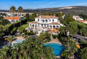 Luftaufnahme der Villa, des Lagunenpools und der gepflegten, weitläufigen Gärten