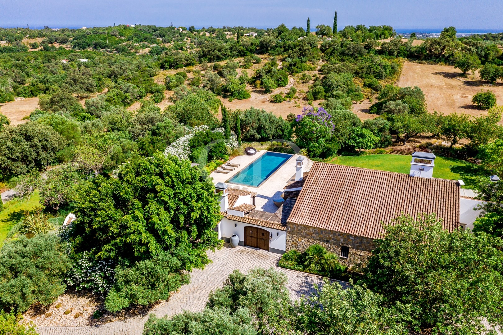 Vista aérea da moradia, da piscina e dos jardins mediterrânicos bem cuidados