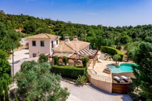 Außenansicht der Villa mit Swimmingpool, Pergola und gepflegten Gärten
