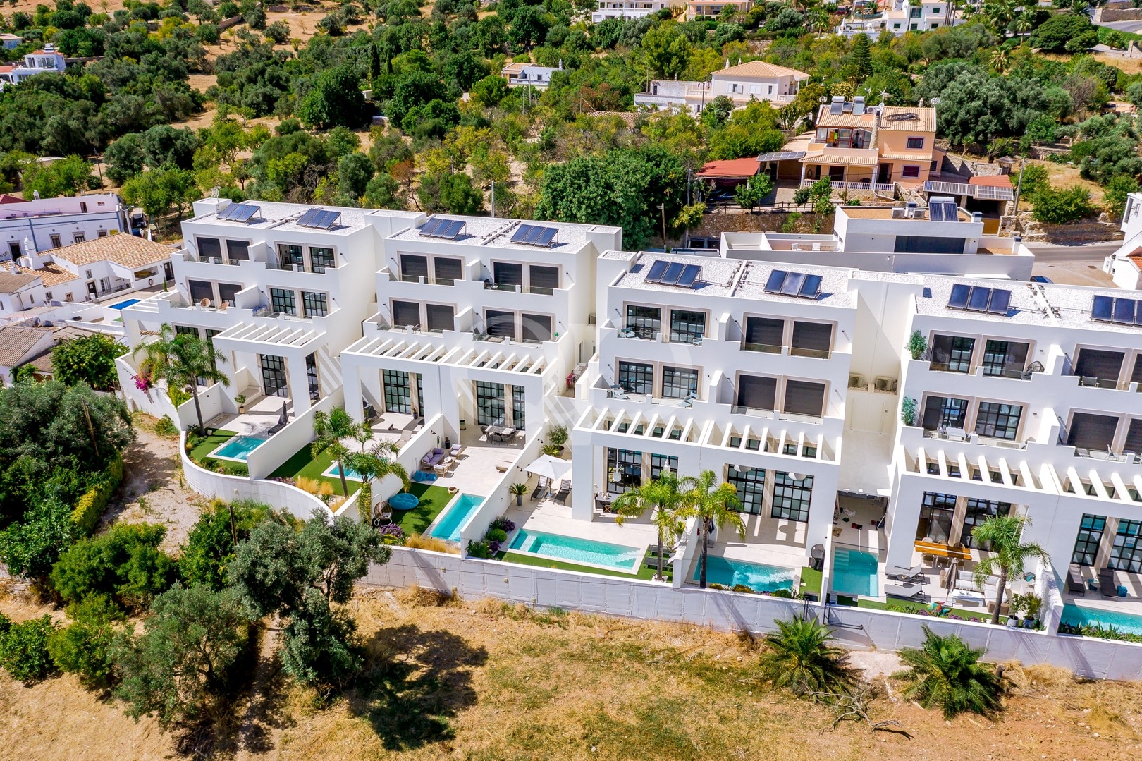 Aerial view of contemporary villa development with private pools