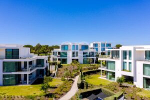 Complexe d'appartements contemporains entouré de jardins paysagers et de pins majestueux