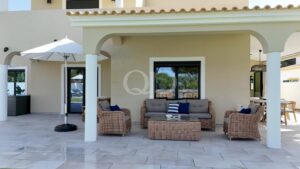 Covered outdoor lounge with garden views and comfortable wicker seating