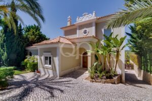 Elegant Mediterranean residence with ornate detailing, arched entrance and lush tropical surroundings