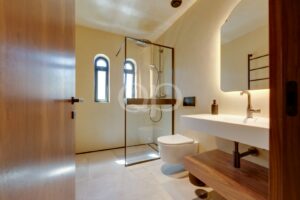 Contemporary bathroom with walk in shower, floating vanity and arched windows