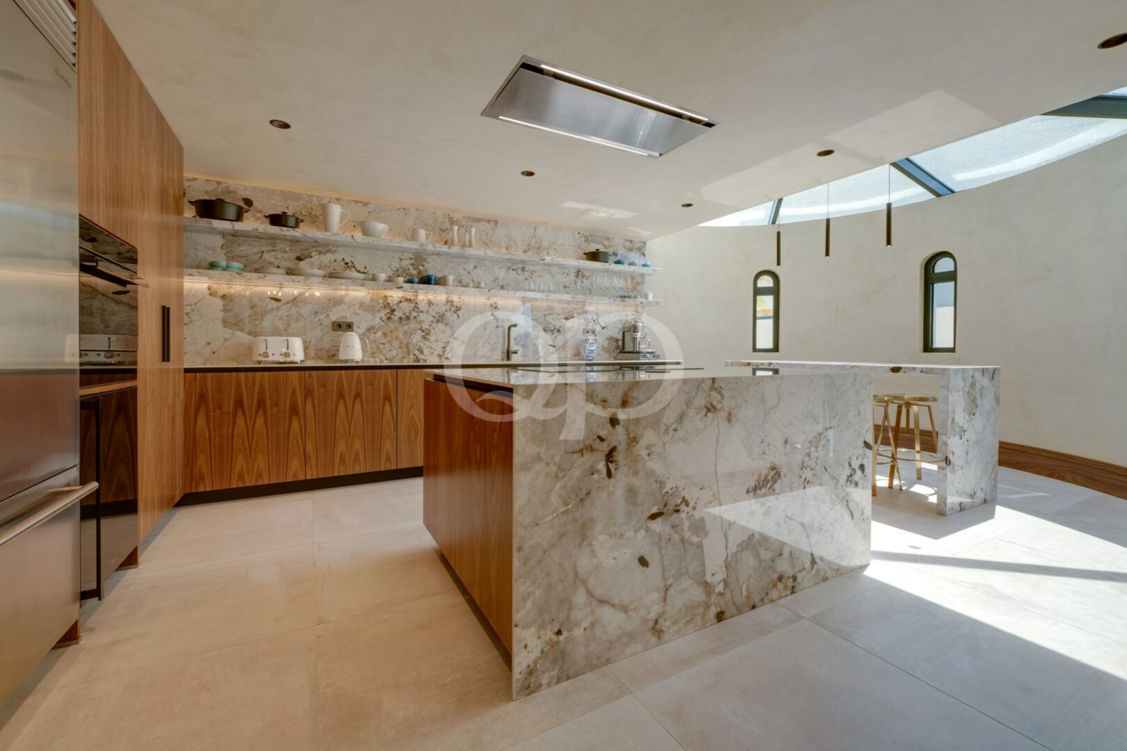 Contemporary kitchen with marble island, wooden cabinetry and integrated appliances